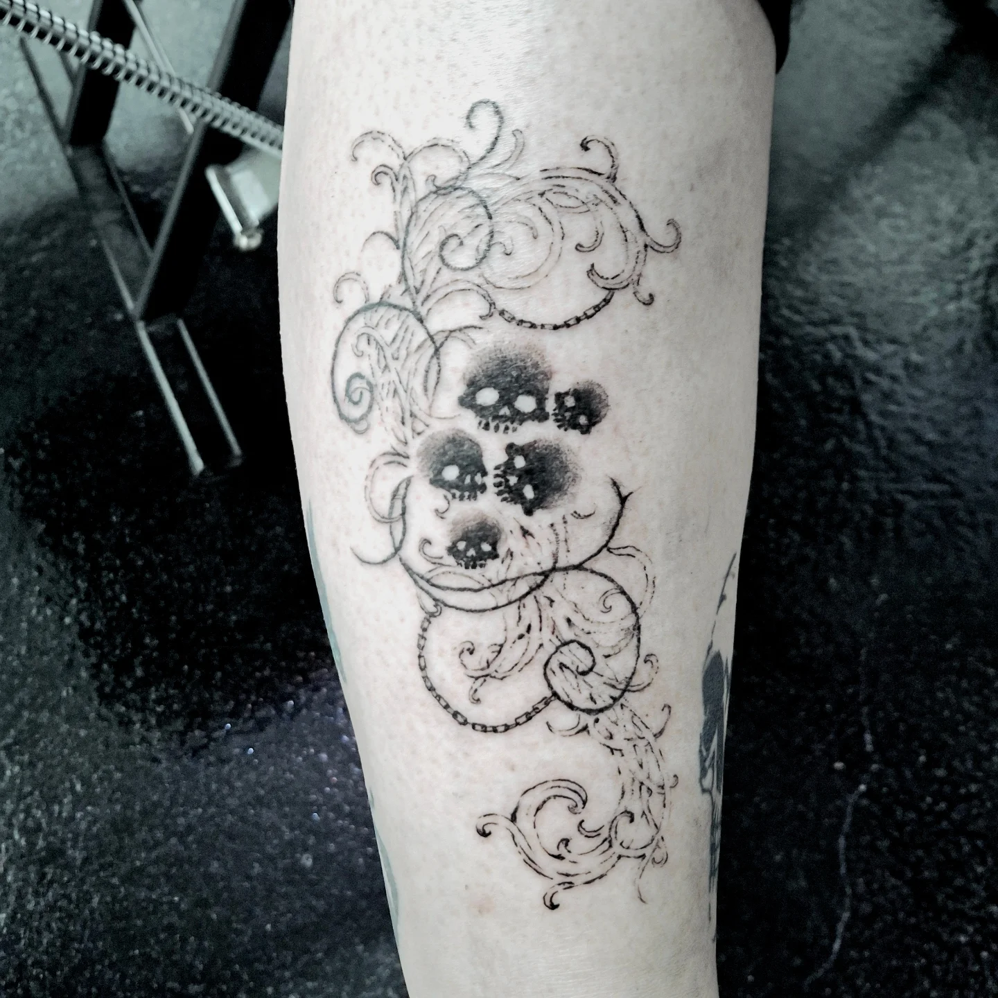 Skulls and swirls black and grey tattoo on the forearm by hallowed girl tattoo