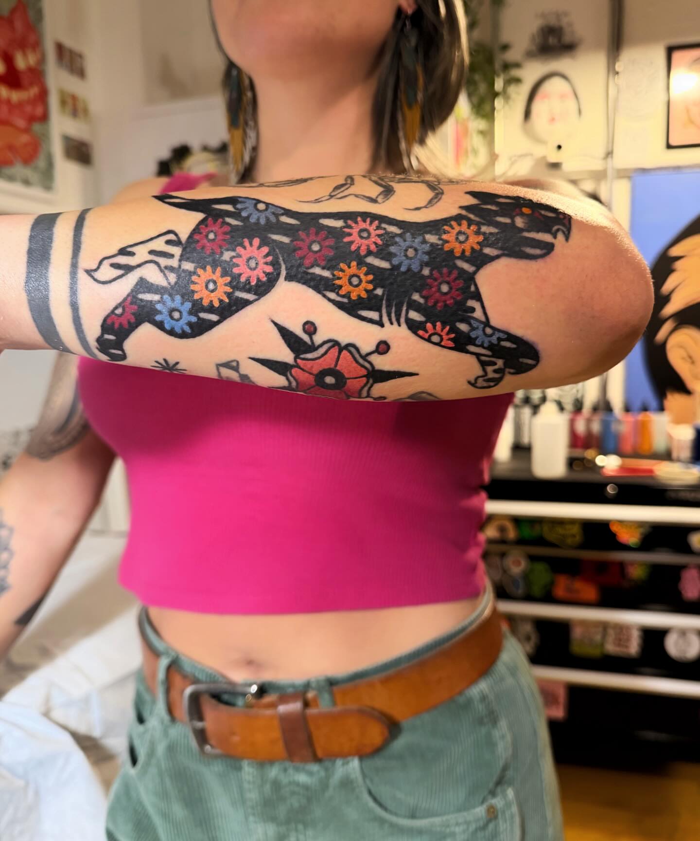 Dog with floral patterns American traditional tattoo on the upper arm by Manee Friday