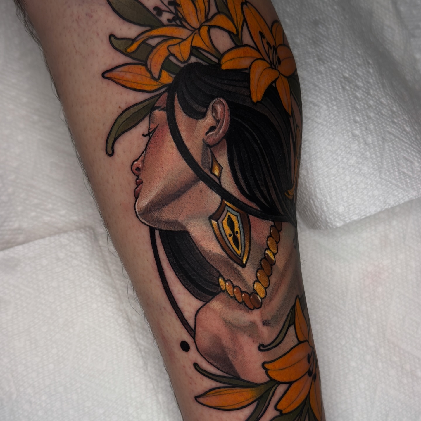 Woman with flowers American traditional tattoo on the forearm by Golden Heart Tattoo Co