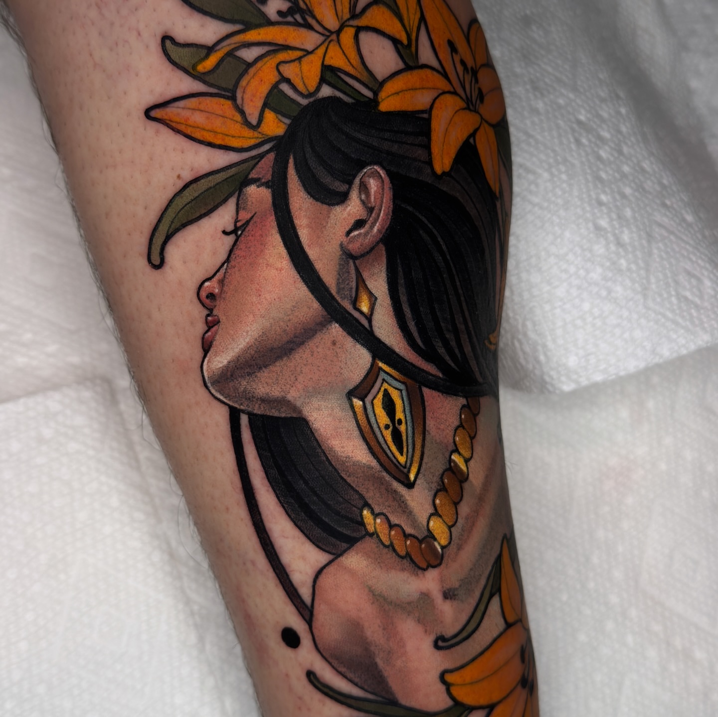 Woman with flowers realism tattoo on the forearm by Golden Heart Tattoo Co