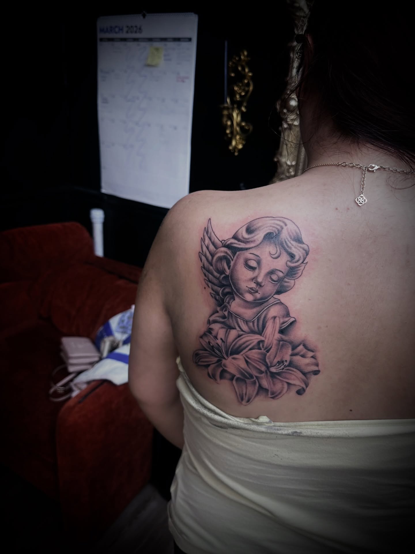 Angel with lilies black and grey tattoo on the back by Kassie Perian