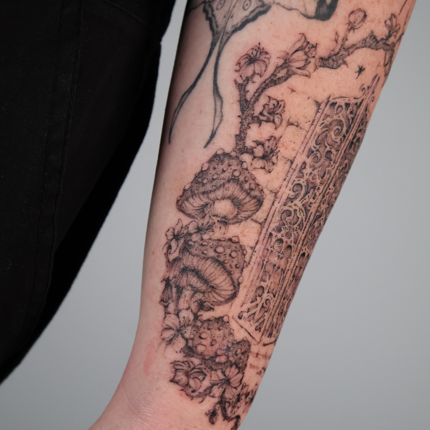 Mushroom and floral arrangement ornamental tattoo on the forearm by Grace Zarmina Hessam