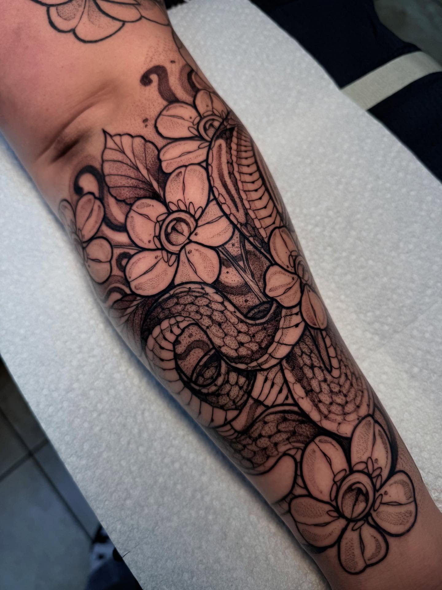 Snake and flowers black and grey tattoo on the forearm by H A N N A H, Colorado Springs, Colorado