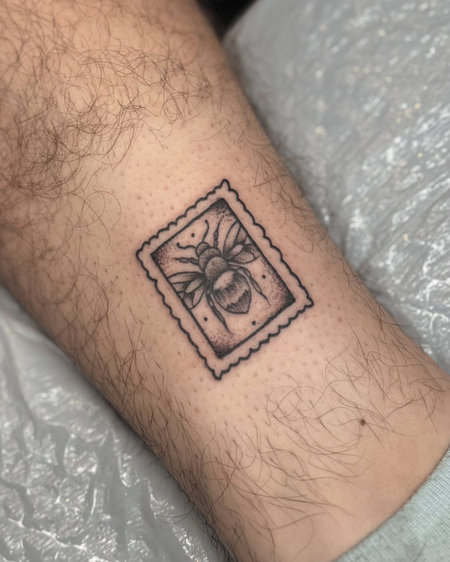 Bee and flower black and grey tattoo on the forearm by Eden Rose, Kalama, Washington