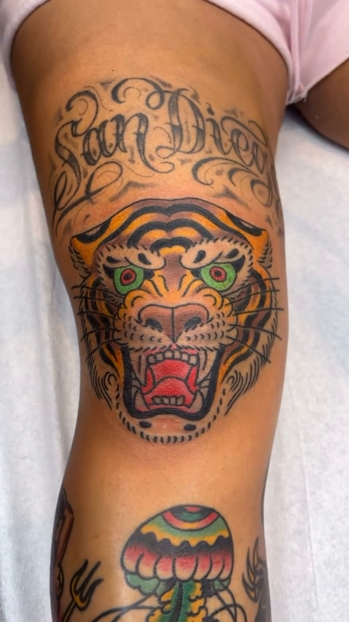 Tiger head with script American traditional tattoo by Graham Niles