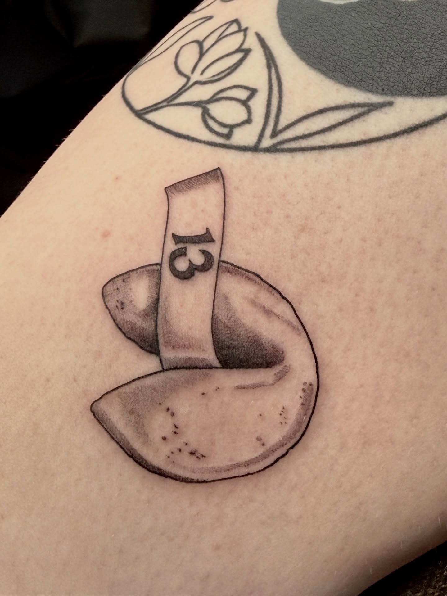 Coin and number black and grey tattoo on the forearm by Lydia Jude