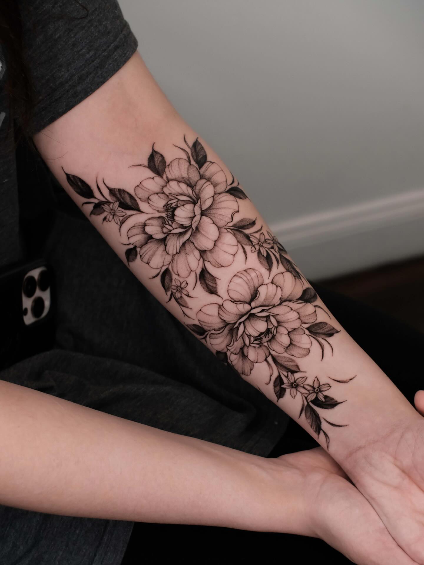 Floral bouquet black and grey tattoo on the forearm by Anastasiia