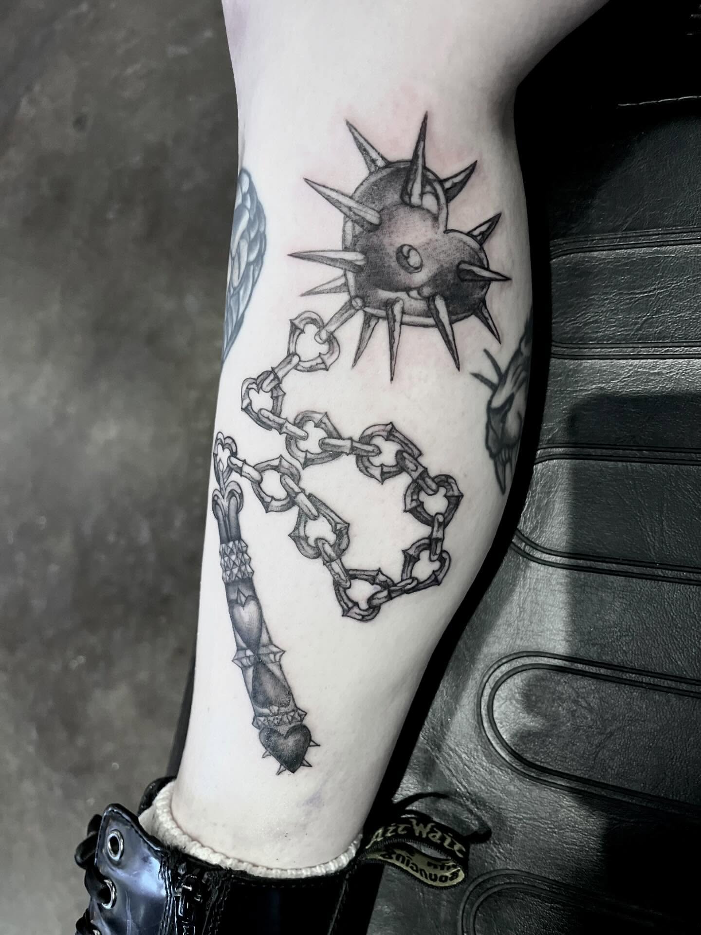 Spiked orb with chain black and grey tattoo on the forearm by Nathan Esteras
