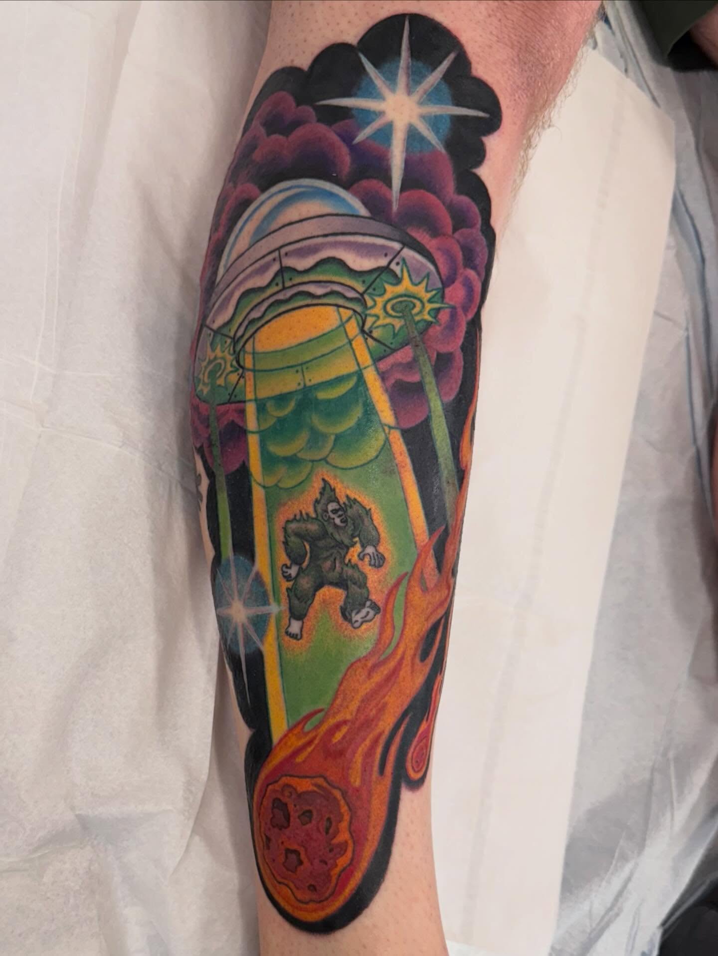 Space-themed scene new school tattoo on the forearm by Michael Joy