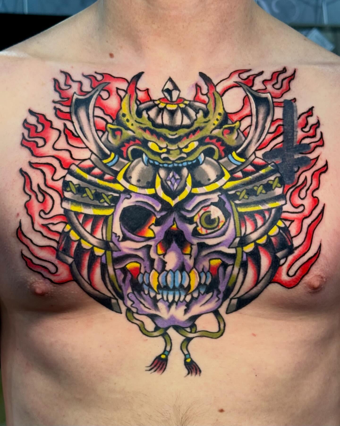 Skull with samurai helmet American traditional tattoo on the chest by Ty Elias