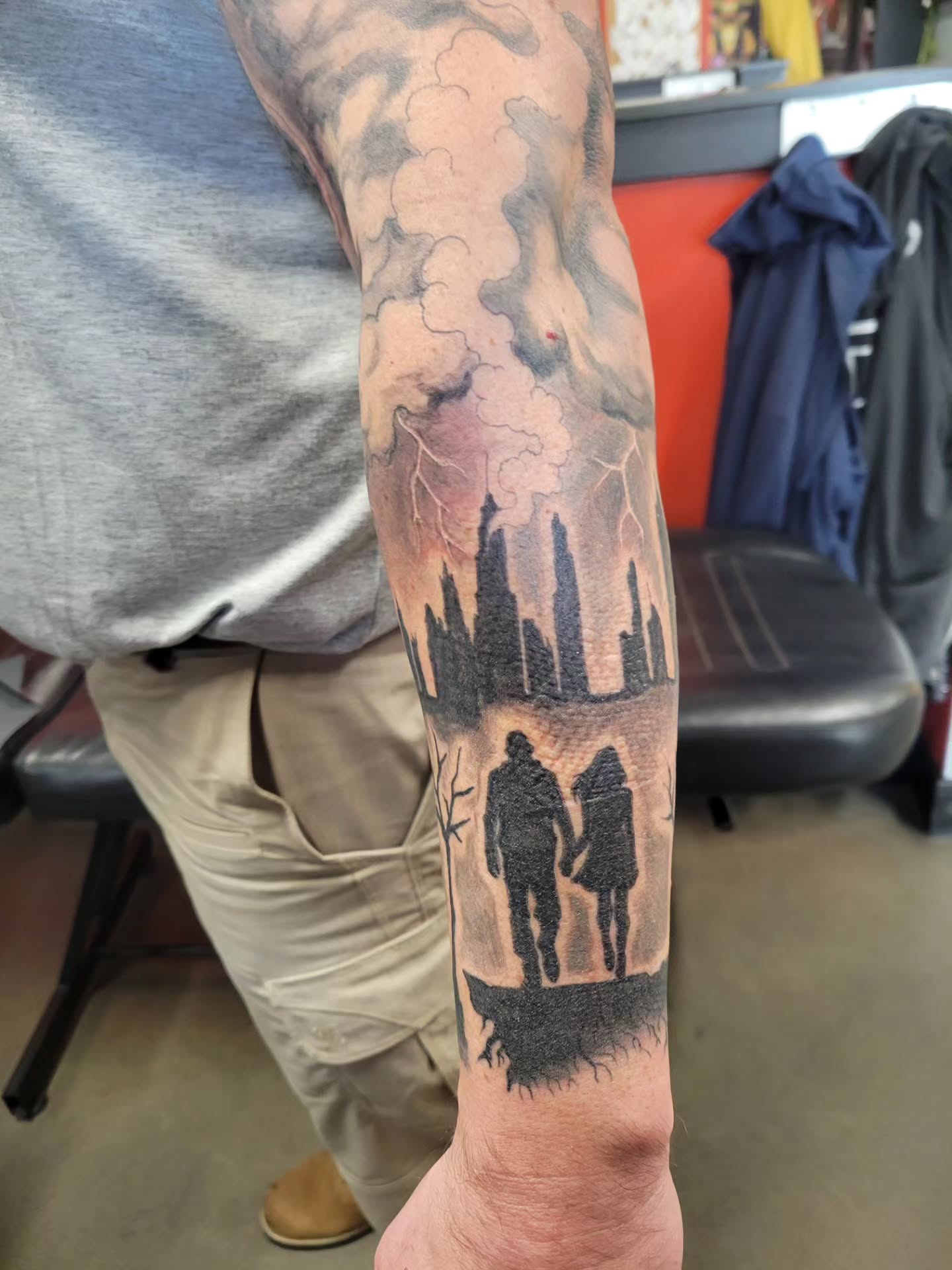 Cityscape with couple realism tattoo on the forearm by Aspen C
