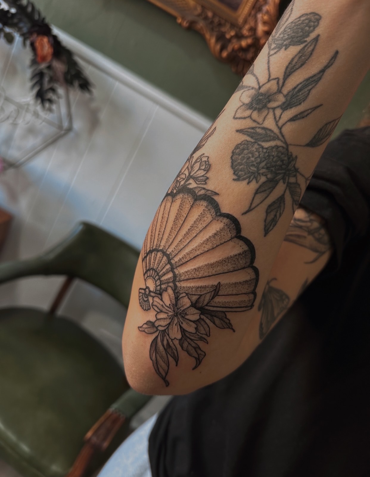 Shell and floral black and grey tattoo on the forearm by Allexis