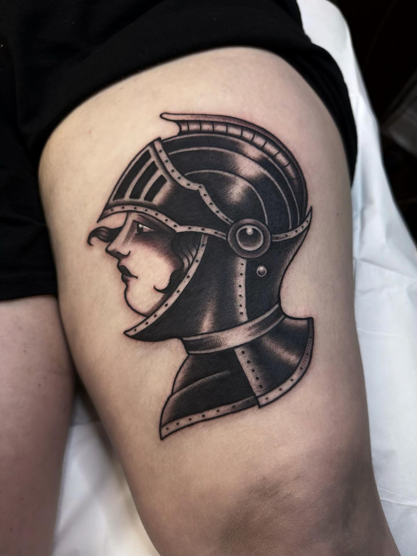 Helmeted profile black and grey tattoo on the thigh by Trav, Bayville, New Jersey