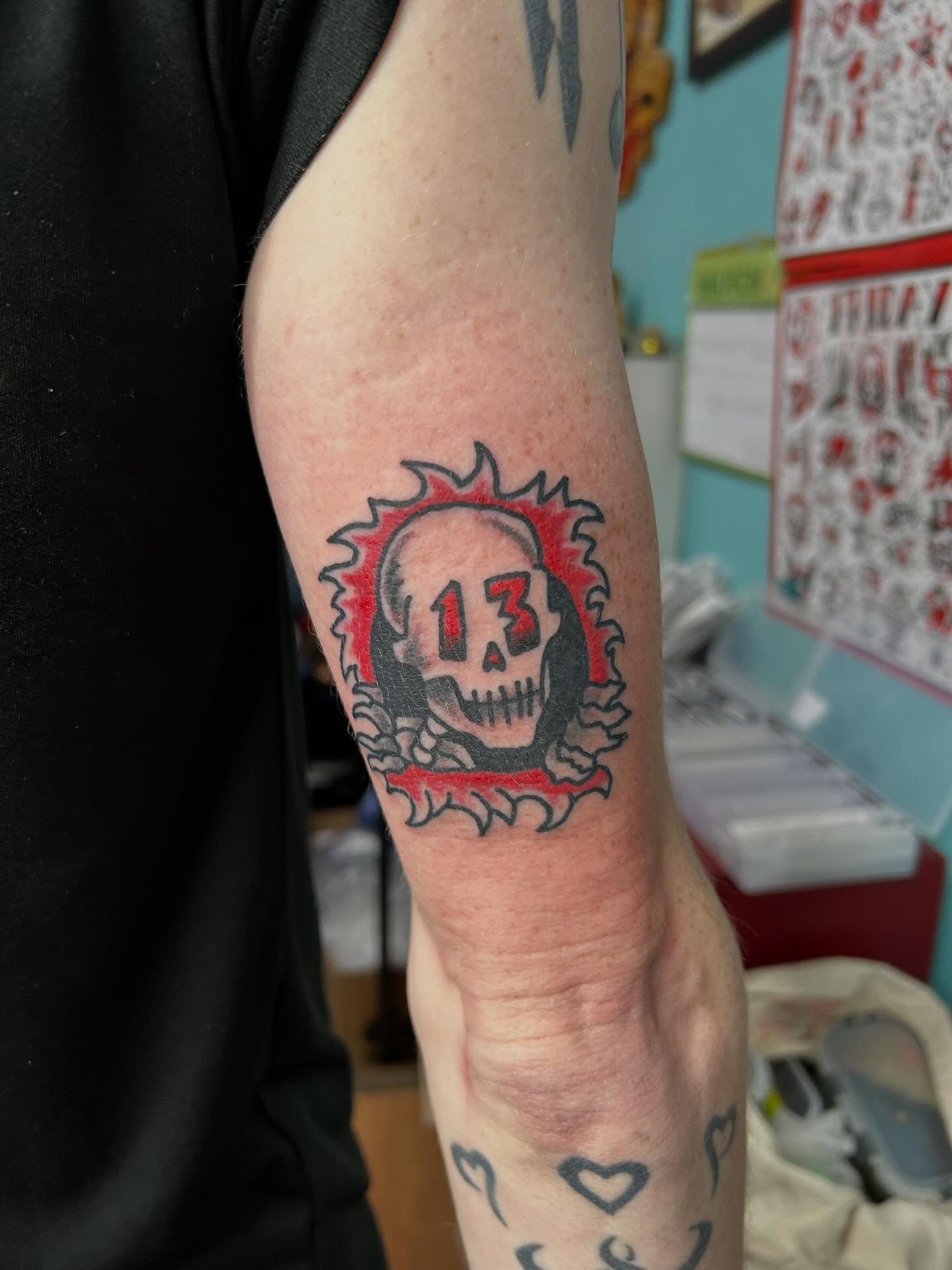 Skull with number 13 American traditional tattoo on the forearm by Elizabeth Niederkorn