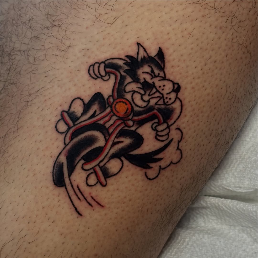 Cartoon cat on a motorcycle American traditional tattoo on the thigh by Gabriel F Kingston Beitia