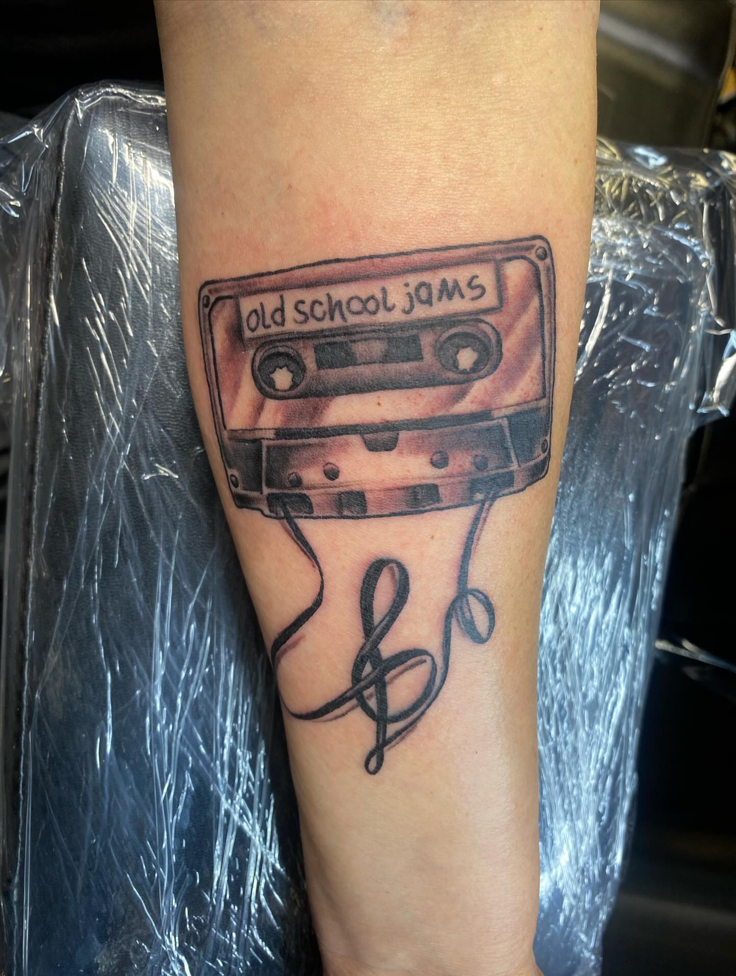 Cassette tape black and grey tattoo on the forearm by Darius Armour (Tattoo Artist)
