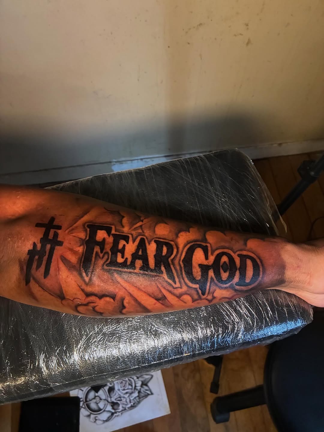 Fear God lettering with crosses Chicano tattoo on the forearm by Detroit tattoo Artist