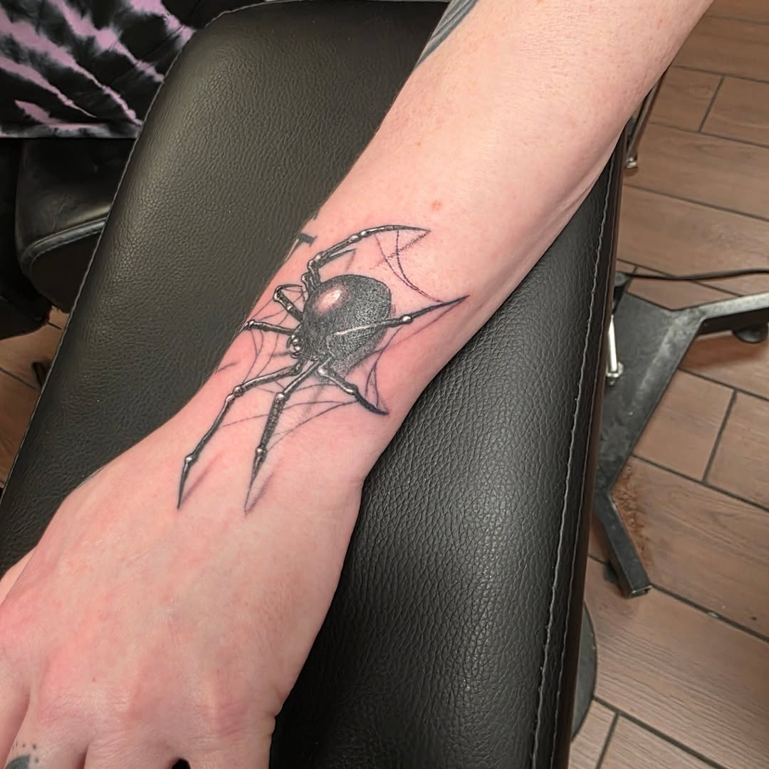 Black widow spider on web blackwork tattoo on the forearm by Jeff Frederick