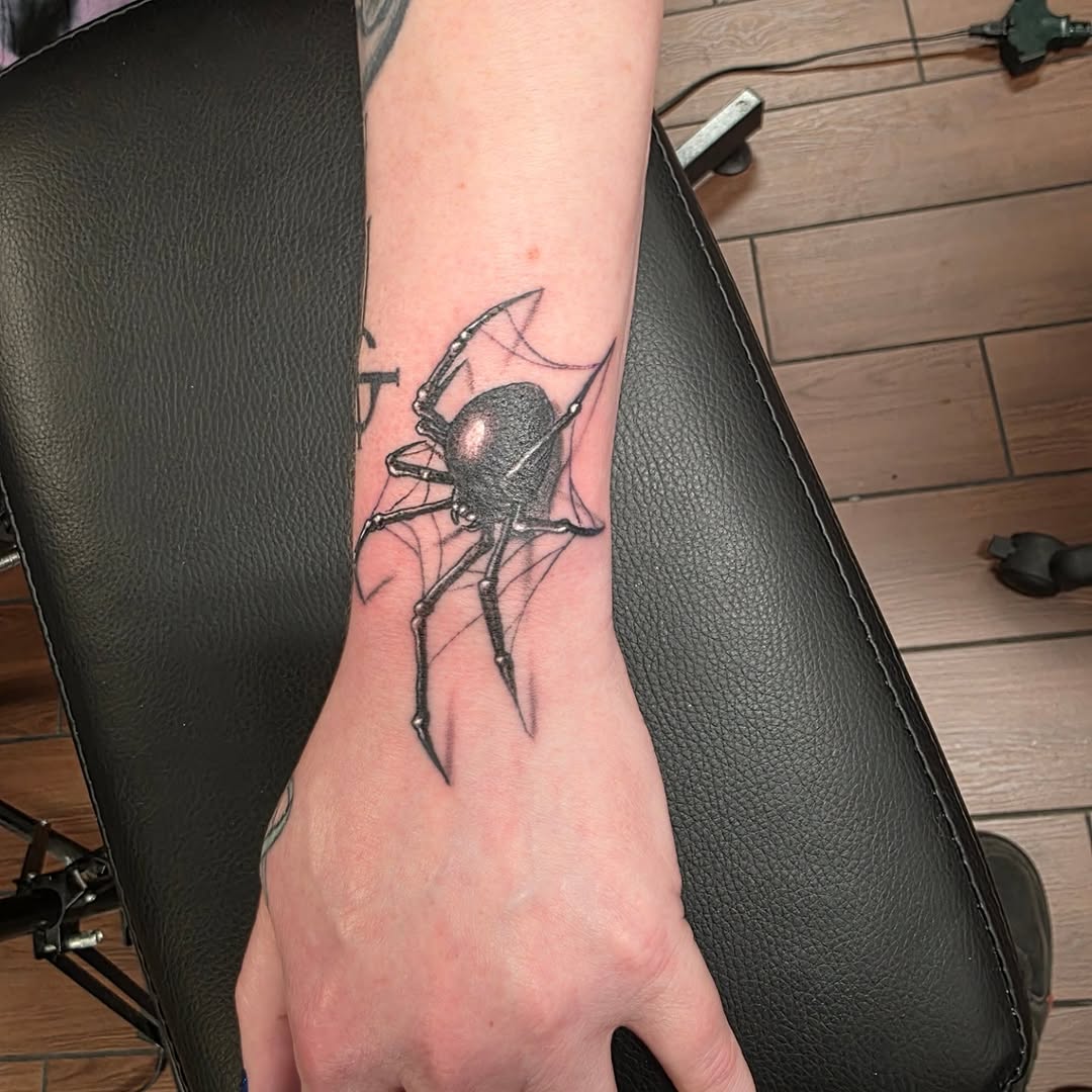 Black widow spider on web blackwork tattoo on the forearm by Jeff Frederick