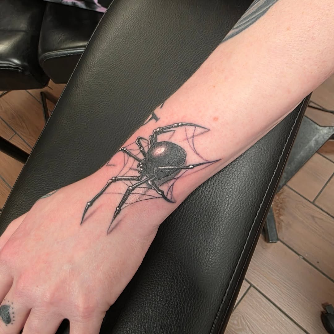 Black widow spider on web blackwork tattoo on the forearm by Jeff Frederick