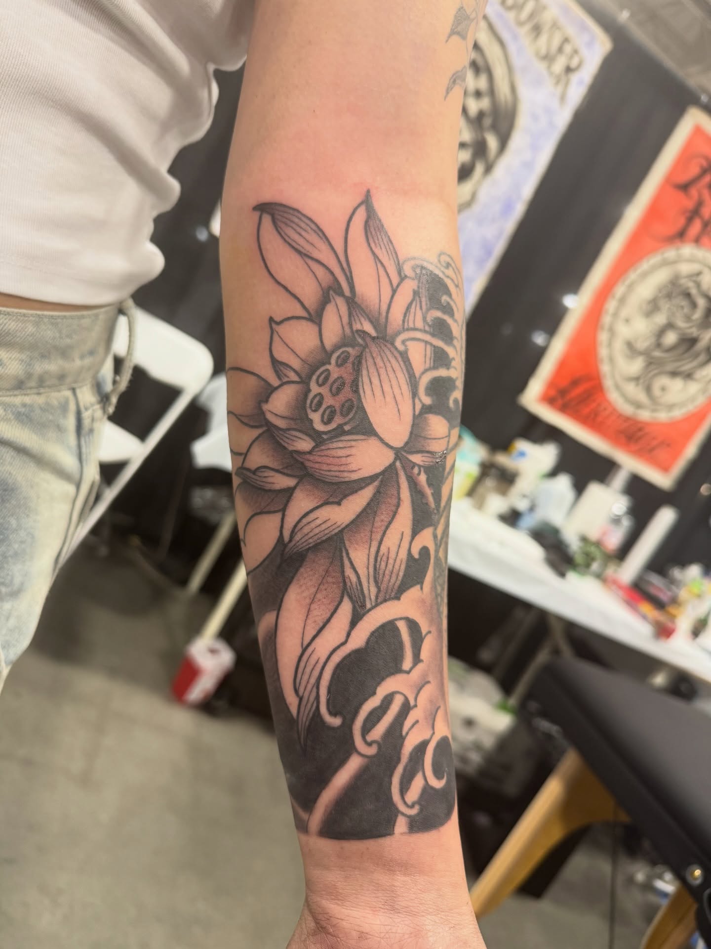 Lotus flower black and grey tattoo on the forearm by Dylan