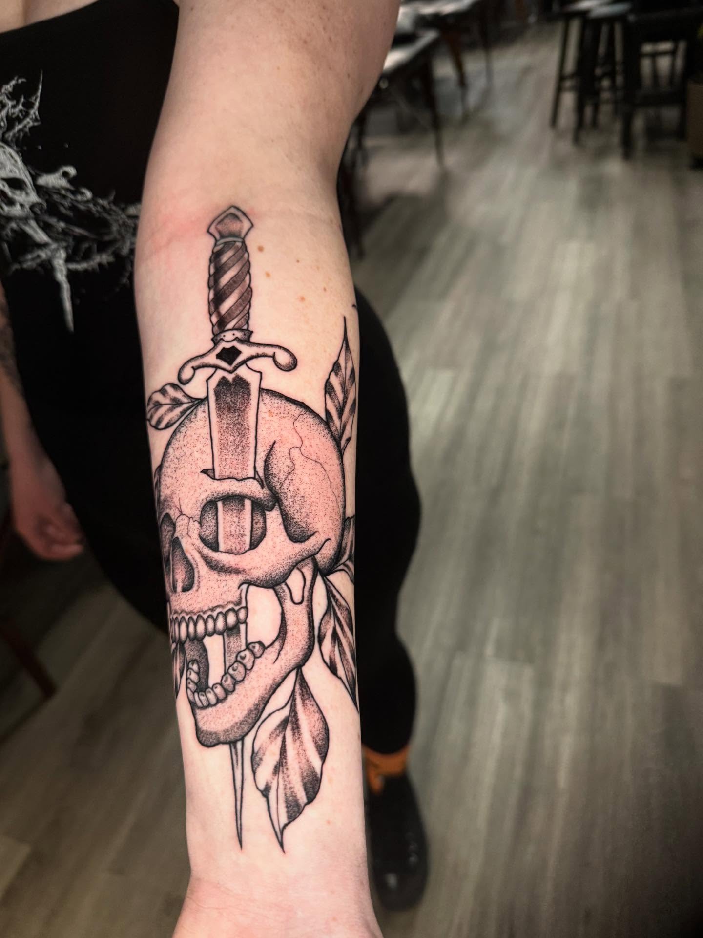 Skull and sword dotwork tattoo on the forearm by Adrián Banuelos