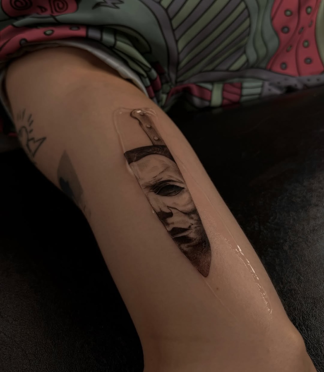 Mask and knife realism tattoo on the forearm by Nina Fedorchenko