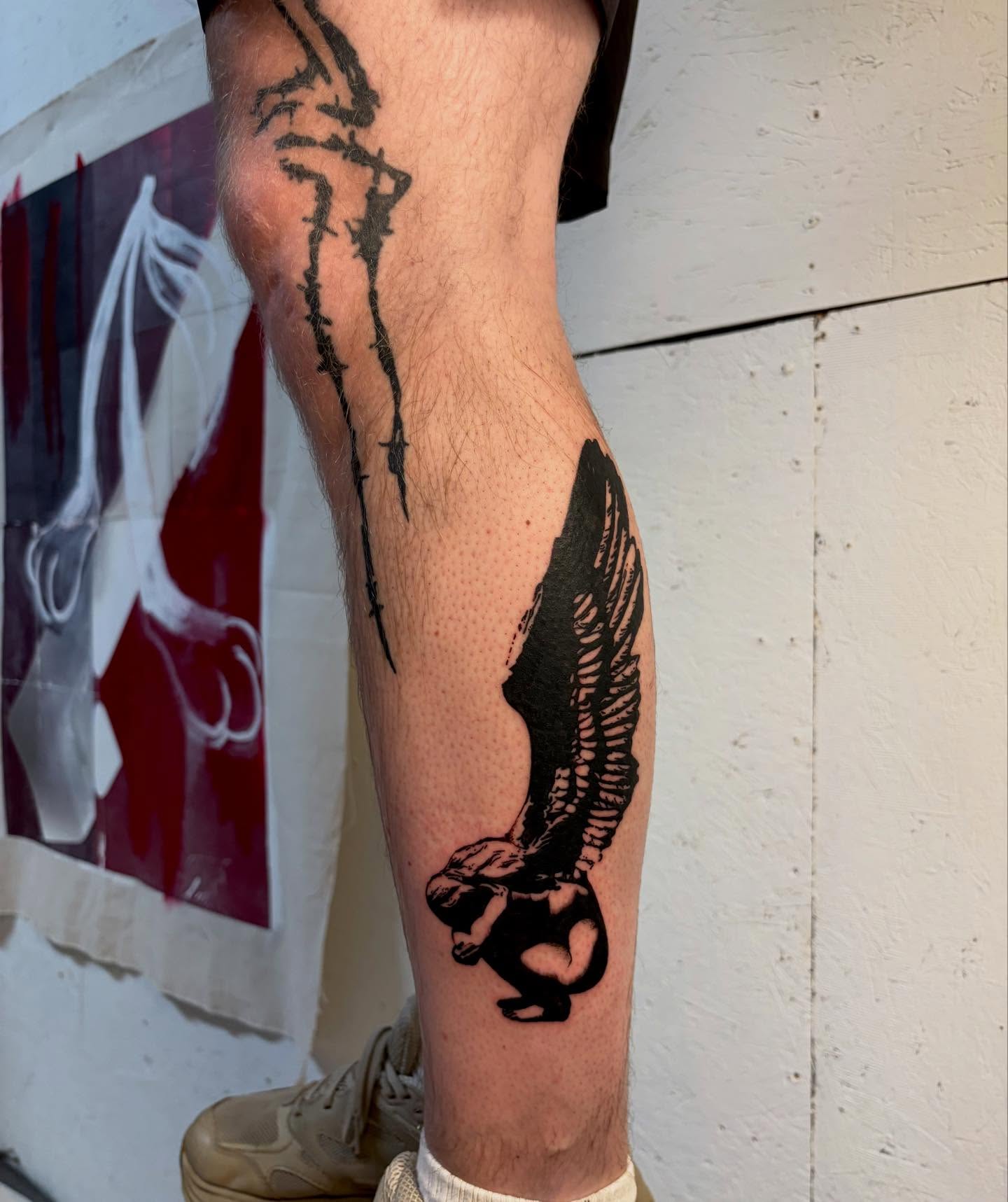 Winged figure black and grey tattoo on the calf by bisabuelita