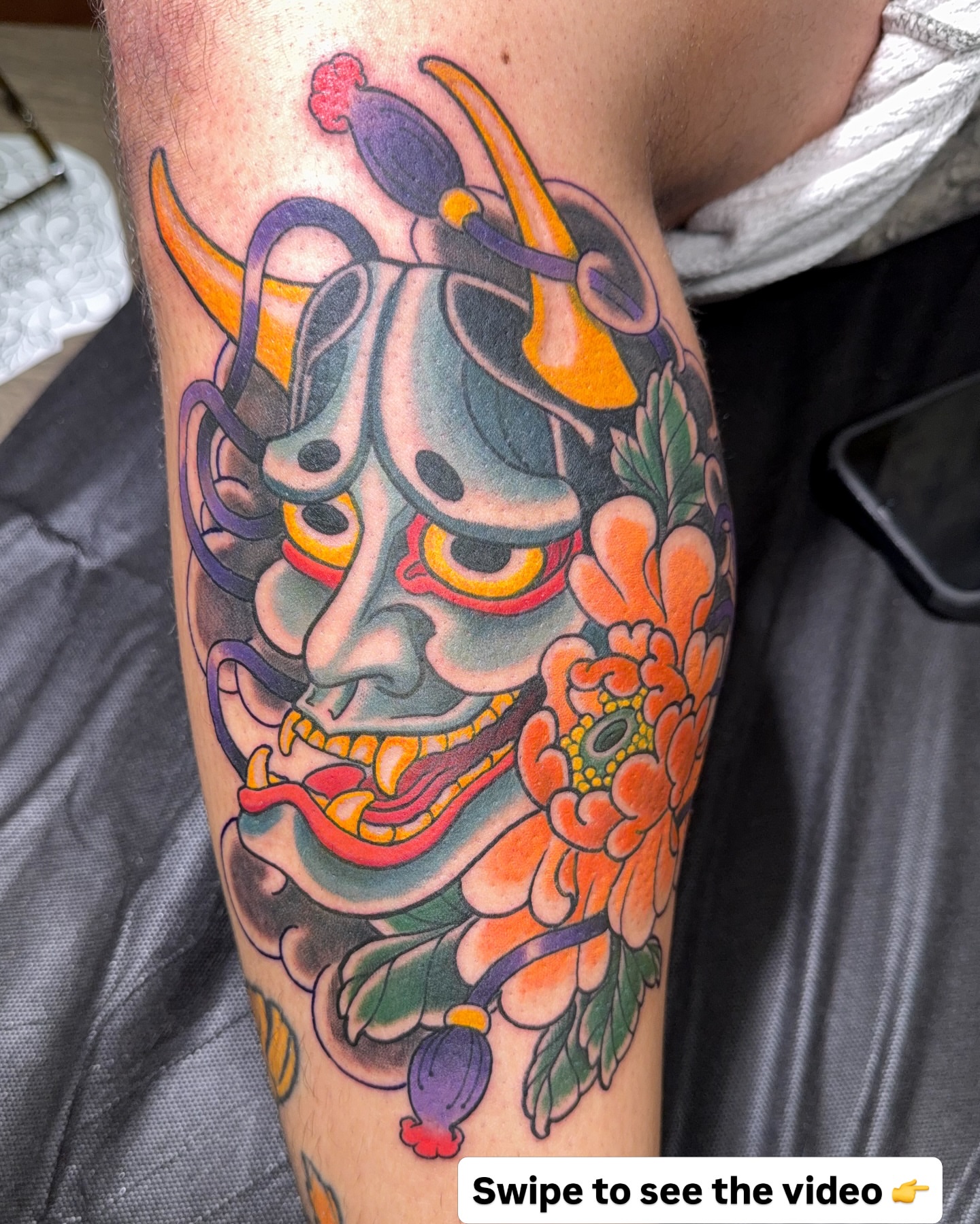 Demon mask with flowers American traditional tattoo on the forearm by James Bird, Vancouver, British Columbia