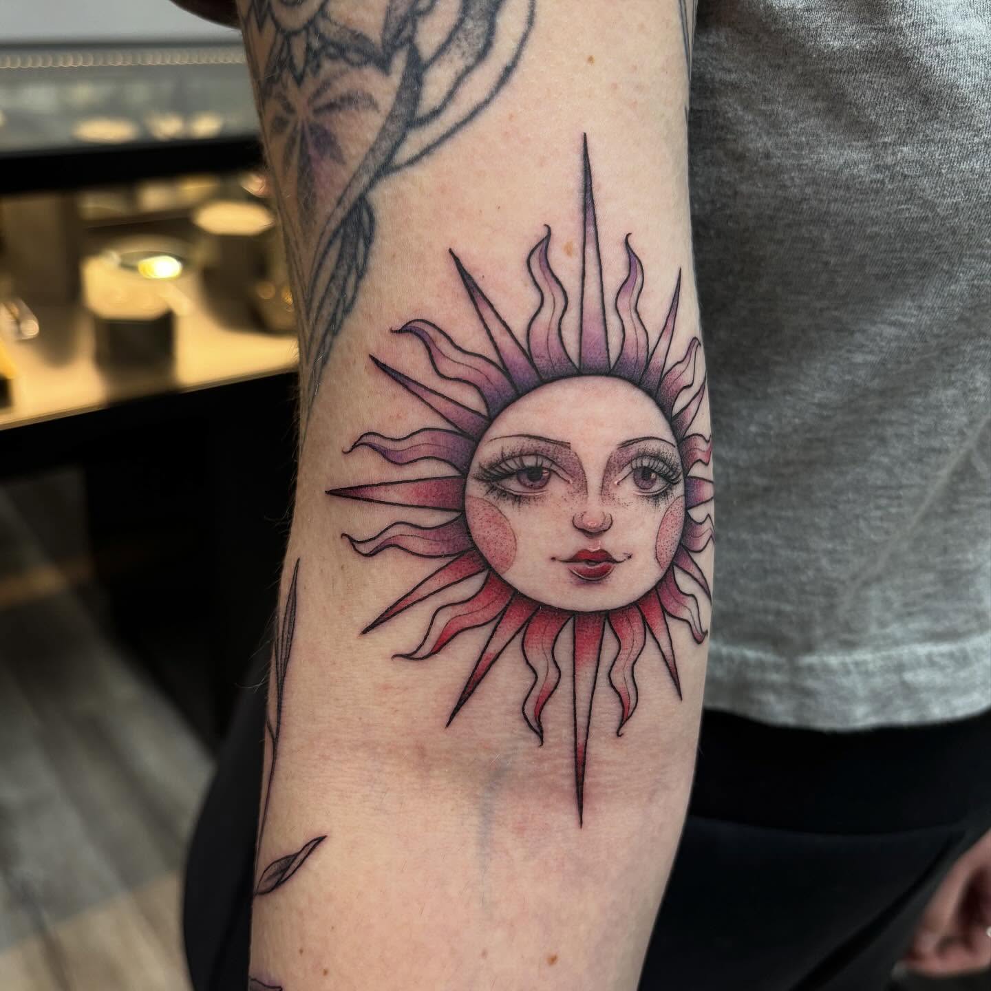Sun face realism tattoo on the forearm by Hailey Nicole