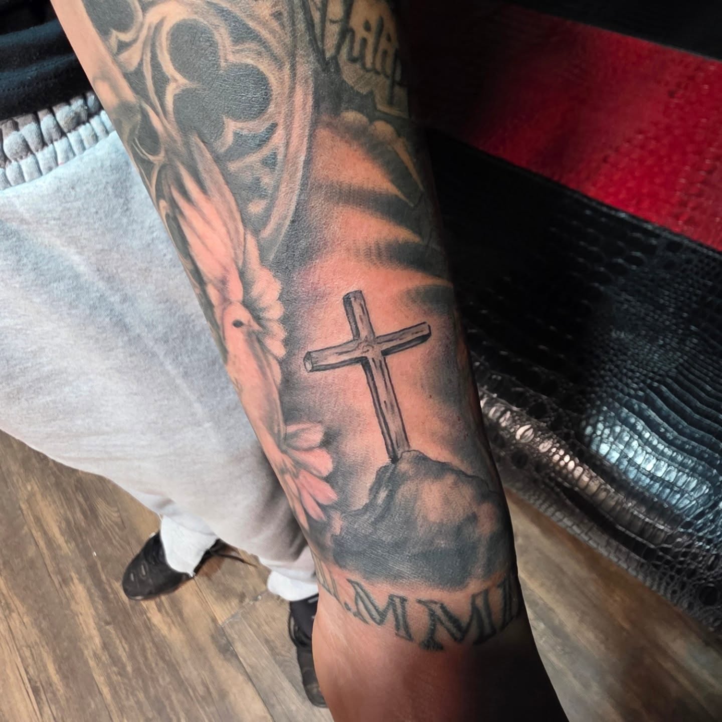 Cross black and grey tattoo on the forearm by komik tattoos