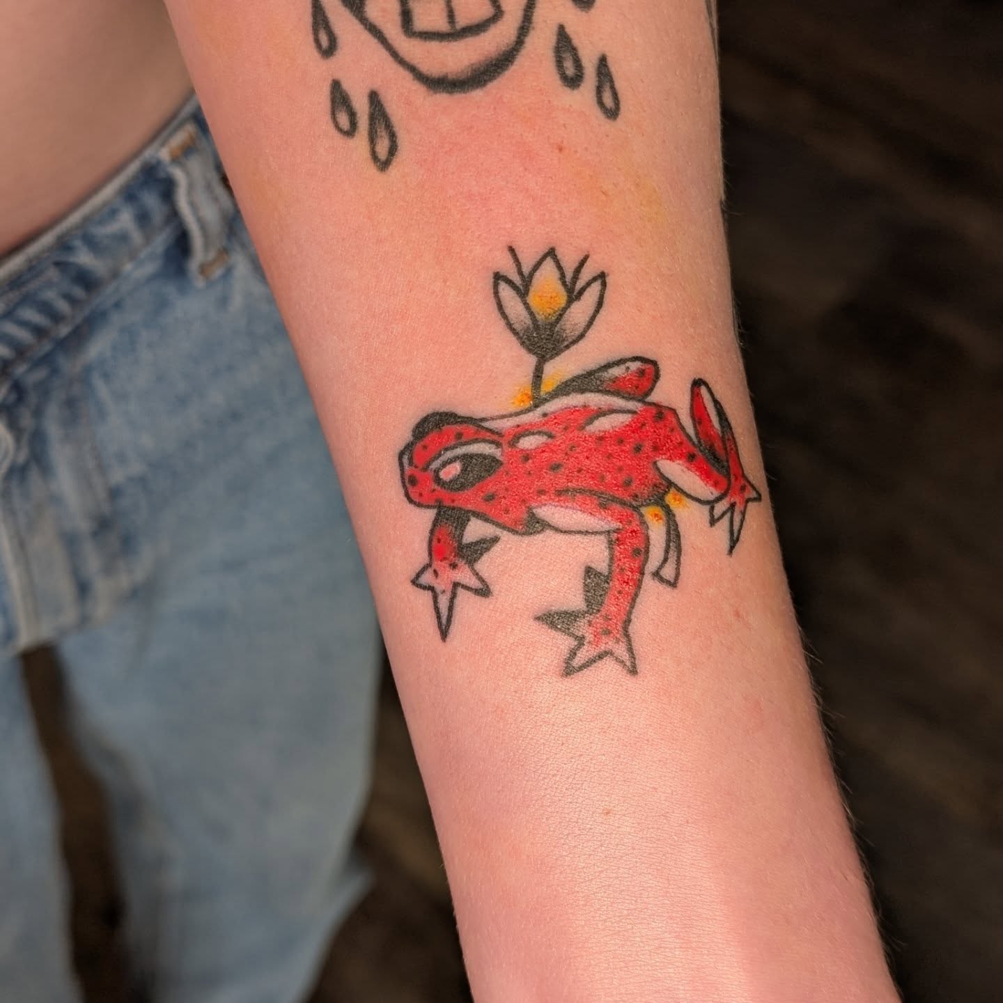 Frog with flower American traditional tattoo on the forearm by Jon Sedor