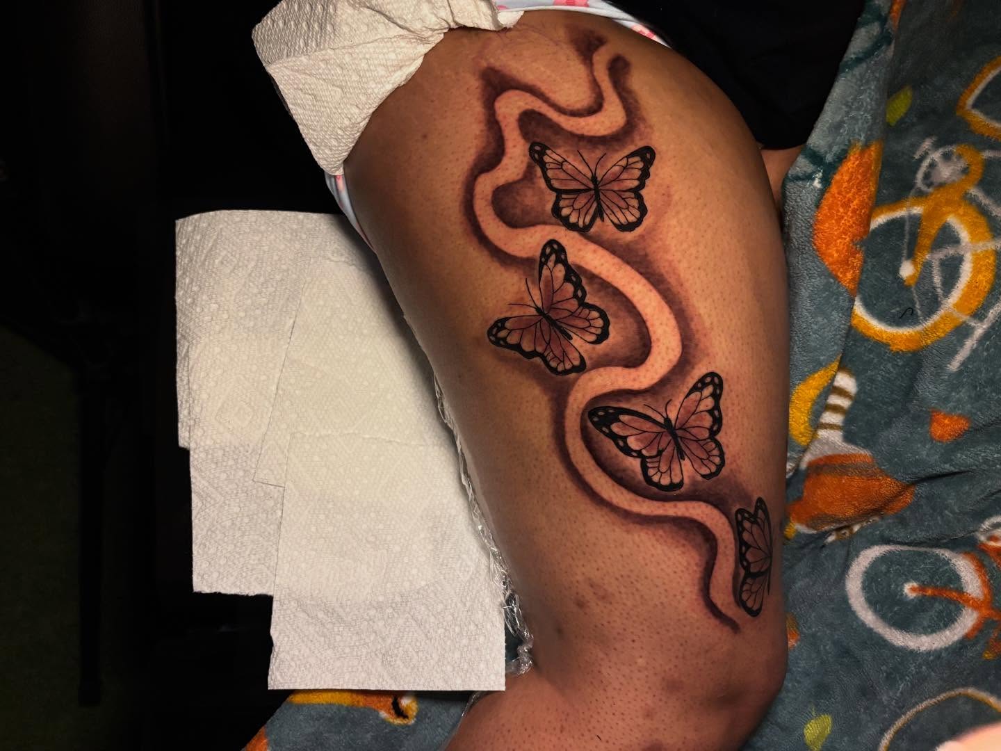 Butterflies and swirls black and grey tattoo on the thigh by Inkys Tatts