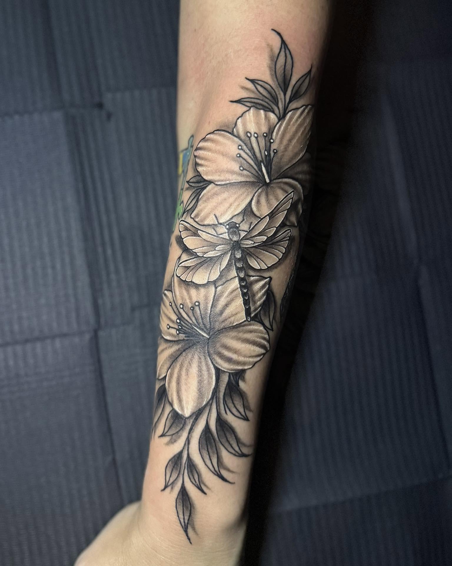 Flowers and dragonfly realism tattoo on the forearm by Corey Bailey, Stanton, Kentucky