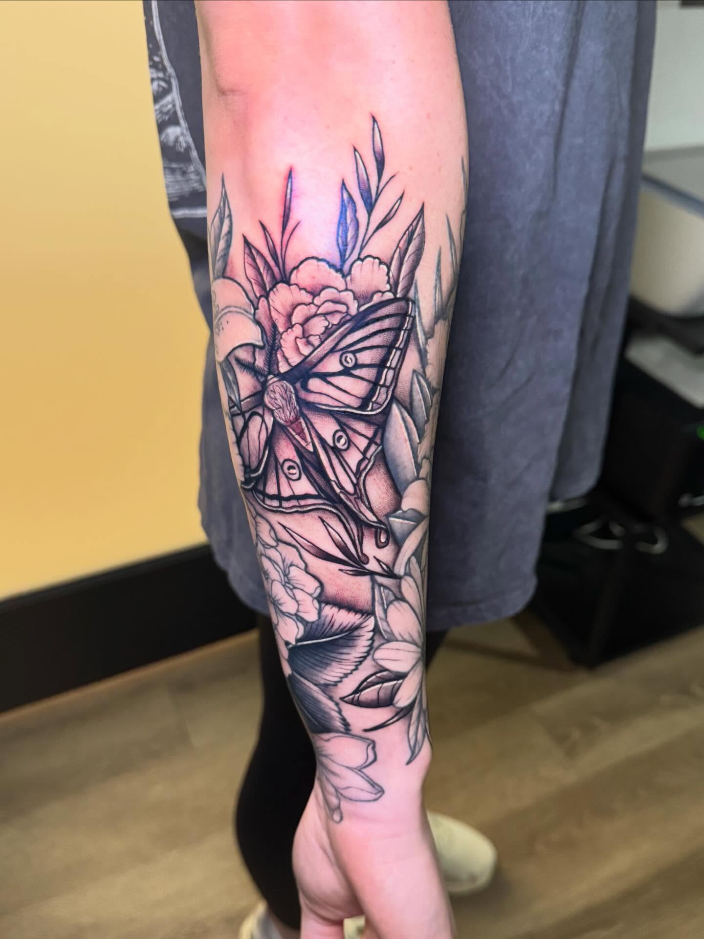 Butterfly and flowers realism tattoo on the forearm by Madison Pegram