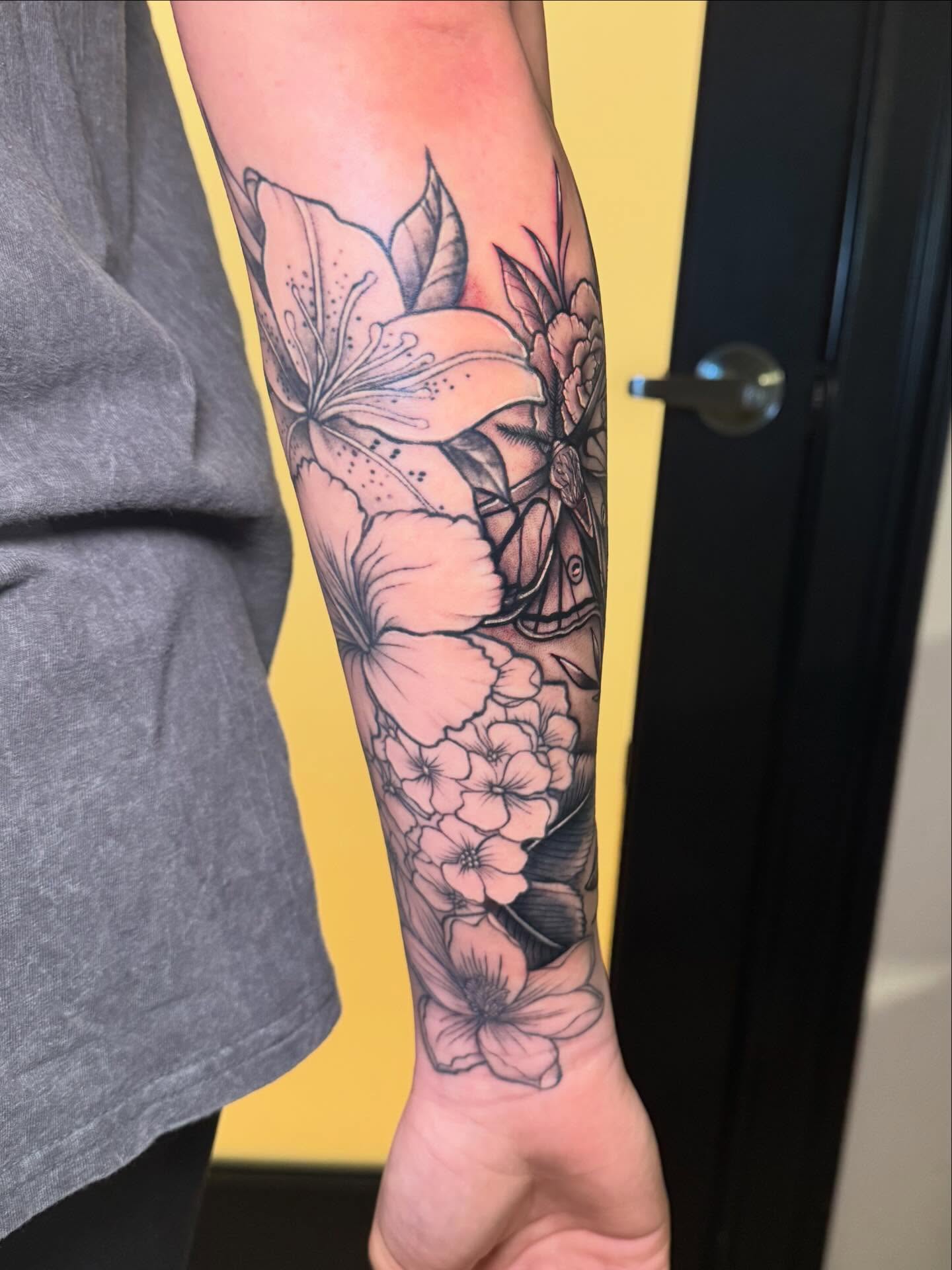 Floral arrangement realism tattoo on the forearm by Madison Pegram
