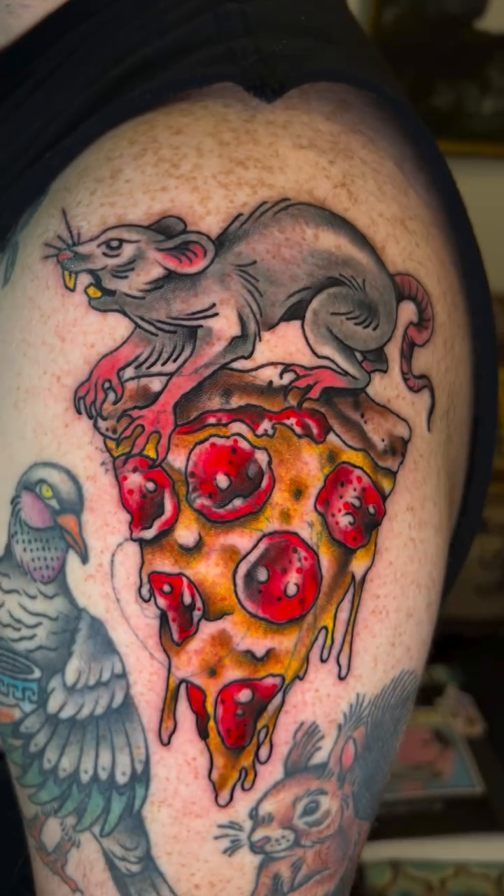 Rat on a slice of pizza American traditional tattoo on the shoulder by Olivia Marie