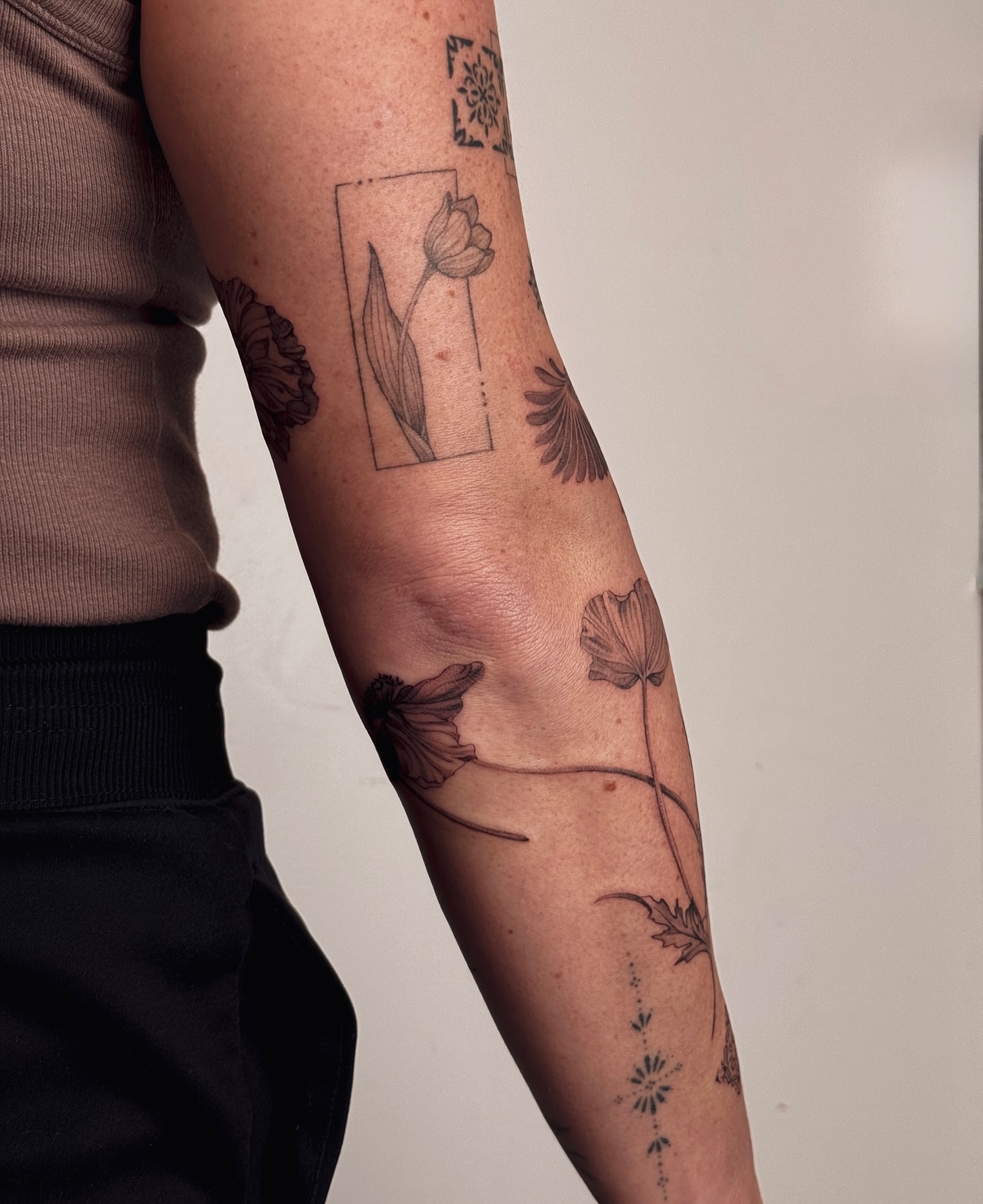 Flowers black and grey tattoo on the forearm by Floral