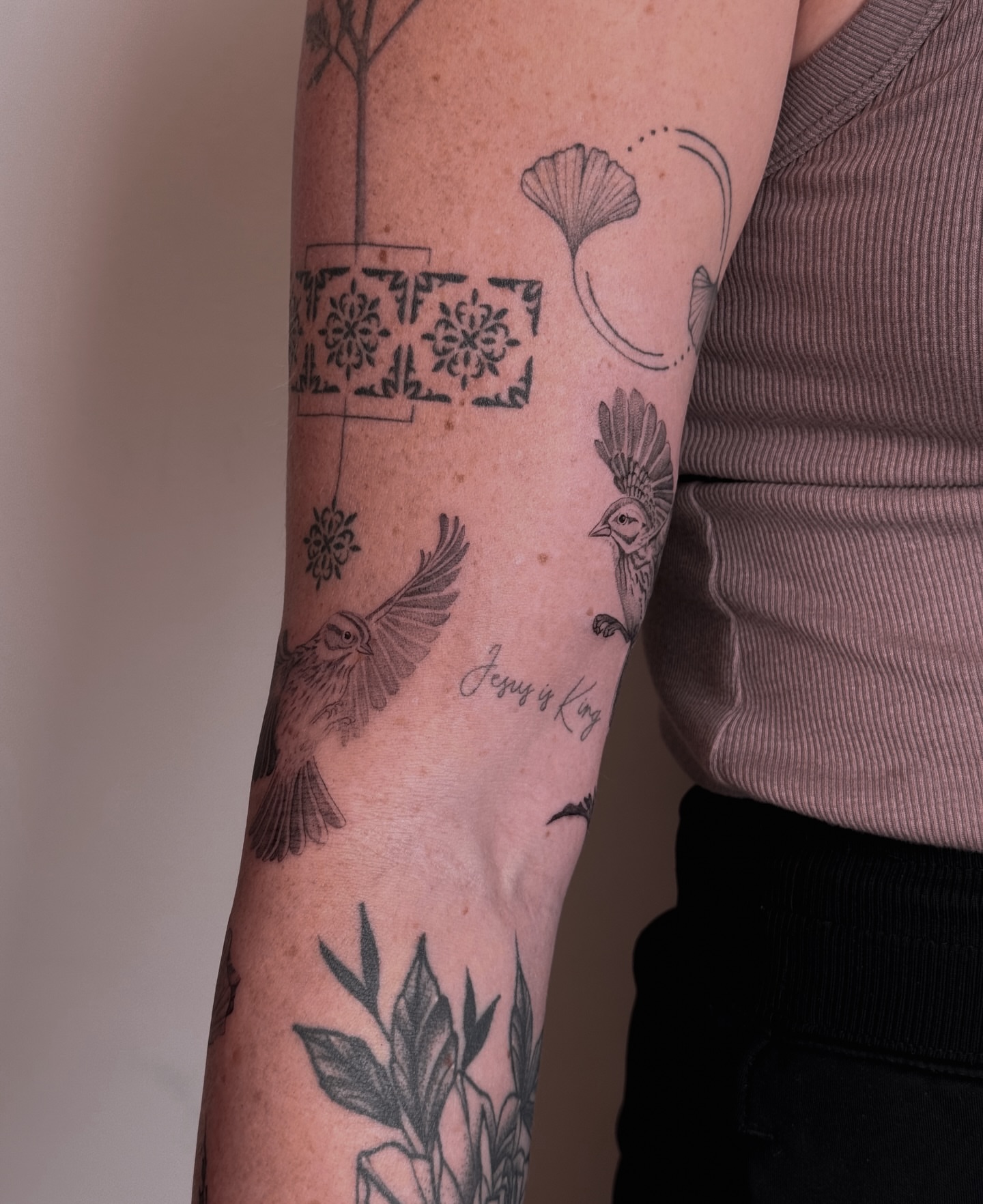 Birds and floral patterns black and grey tattoo on the forearm by Floral