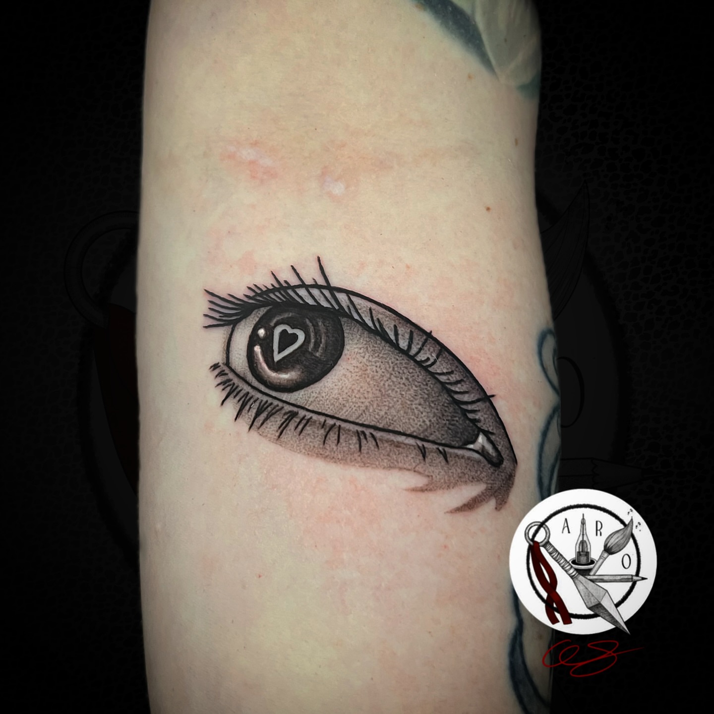 Eye black and grey tattoo on the forearm by Aaron Strobehn