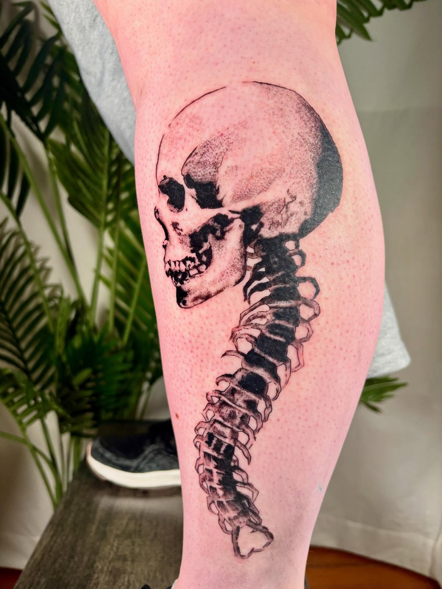 Skull and spine dotwork tattoo on the thigh by Davie Tattoos