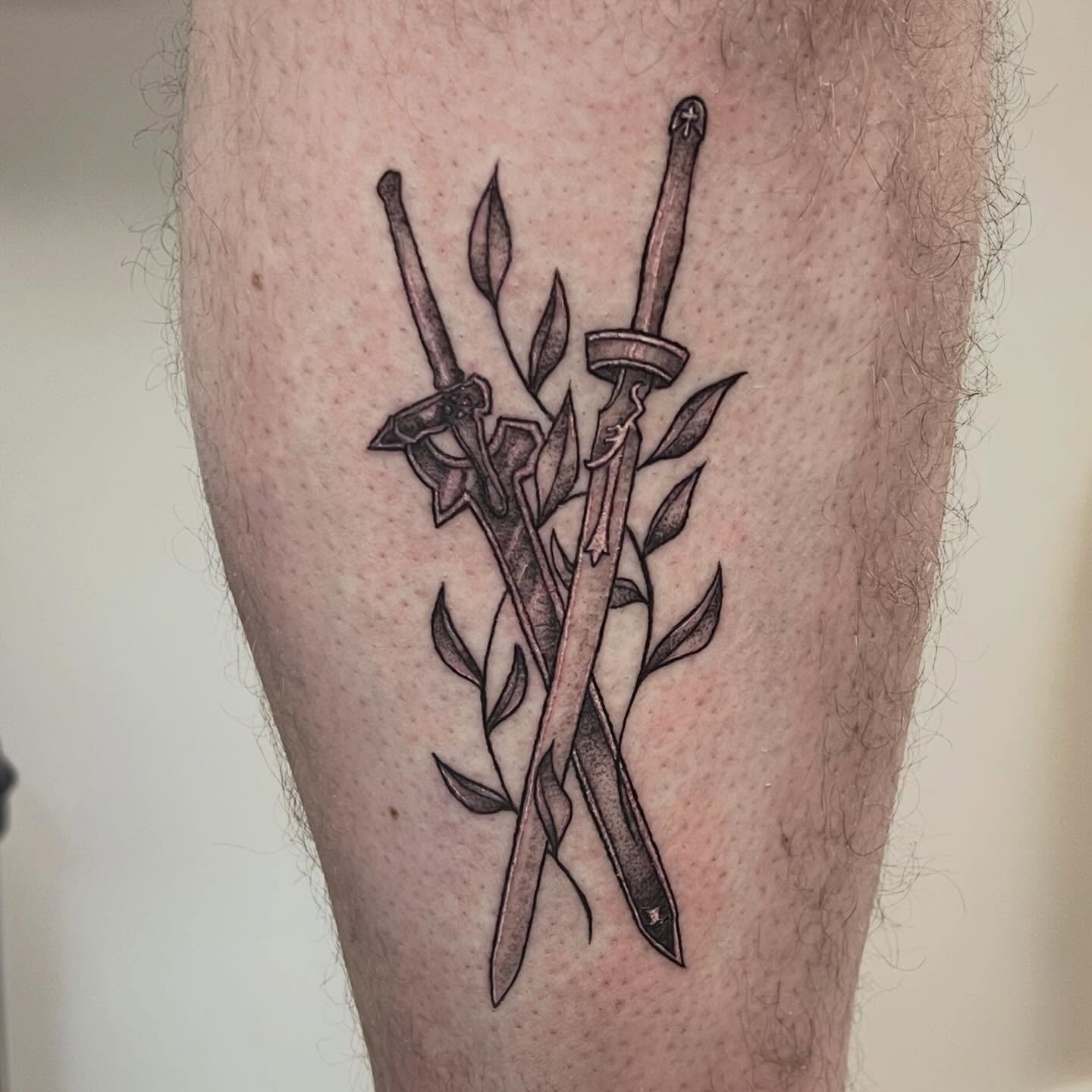 Crossed swords black and grey tattoo on the leg by Amber Rose