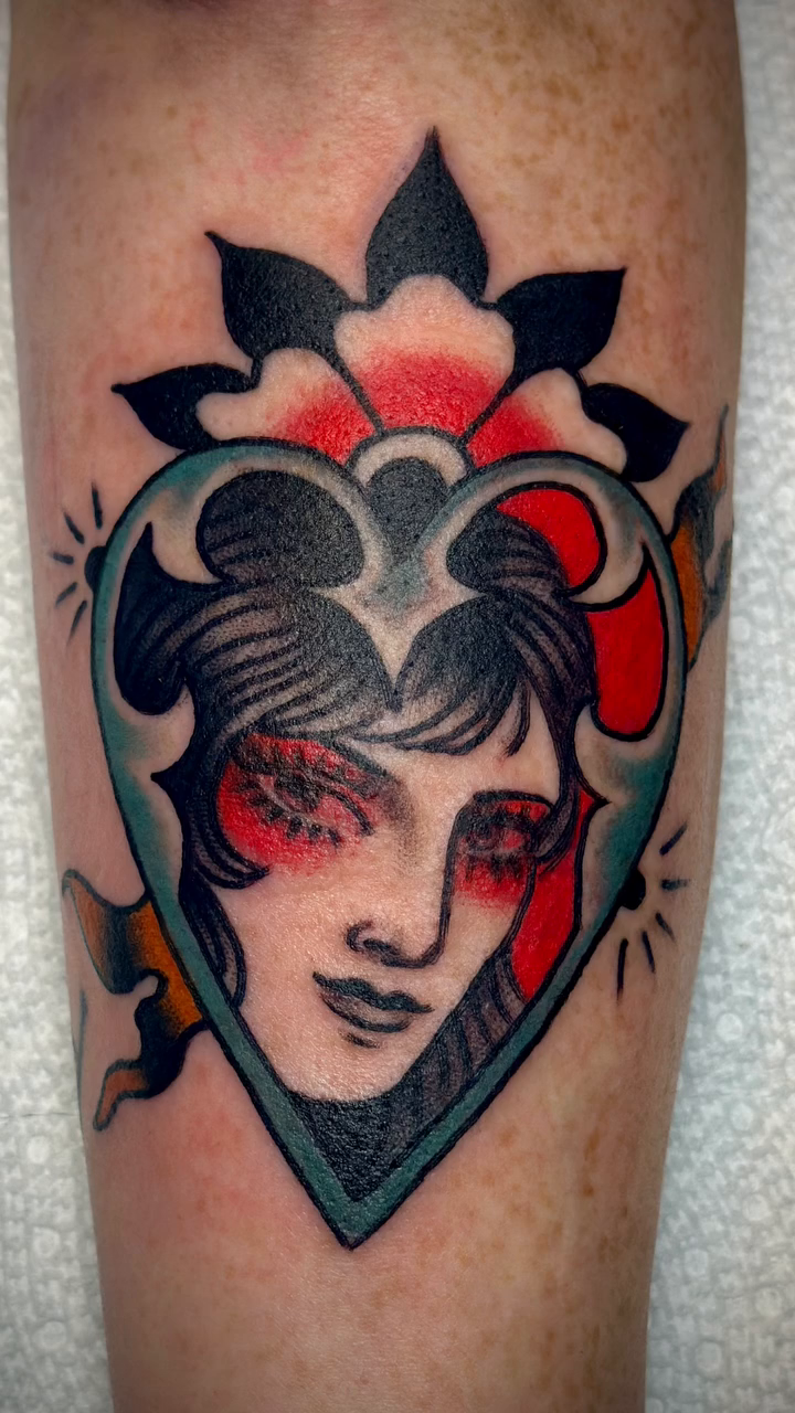 Woman's face in a heart American traditional tattoo by Holly Ellis, San Francisco, California