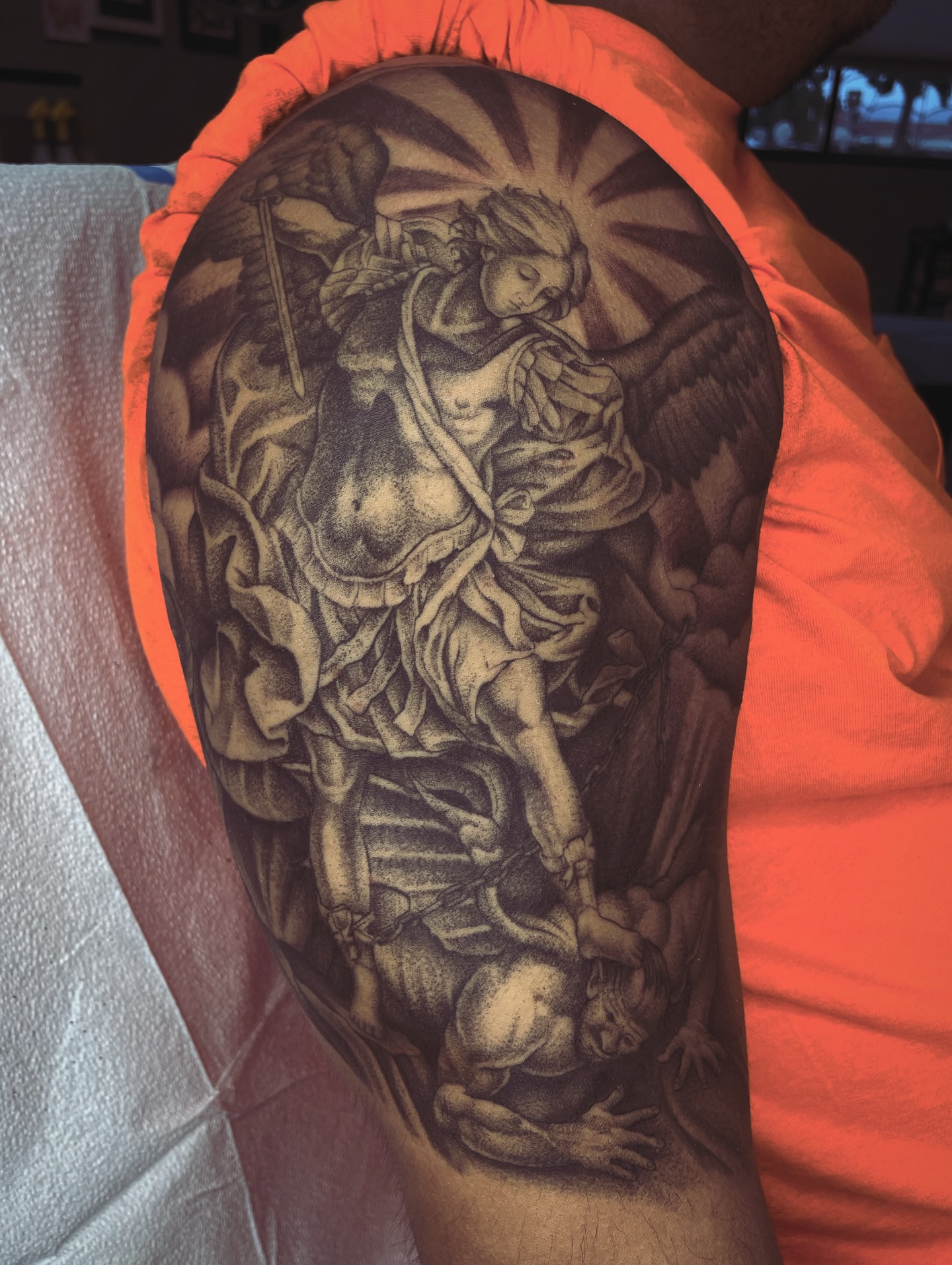 Angel and demon realism tattoo on the upper arm by Andrew