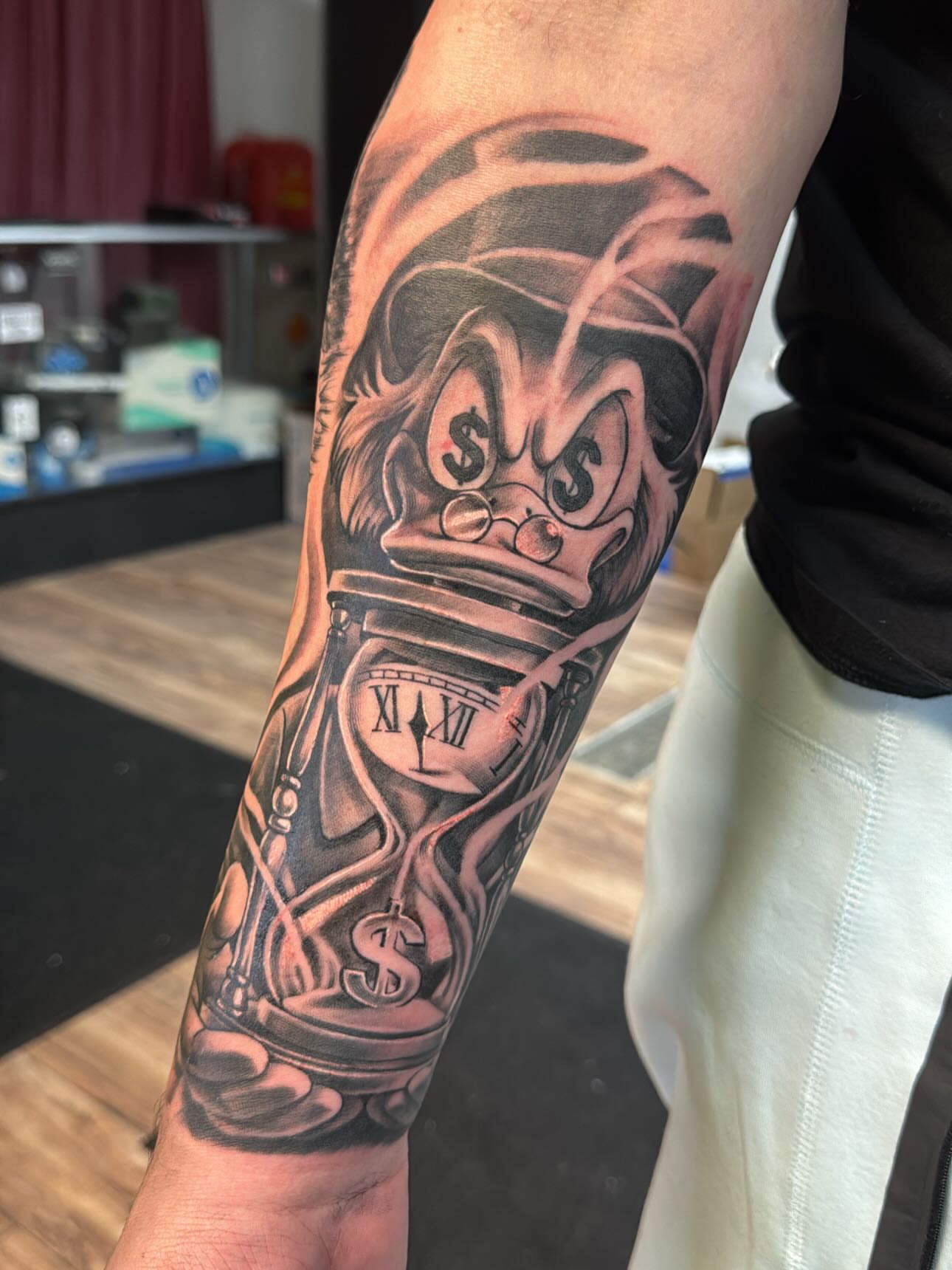 Money bag and clock realism tattoo on the forearm by Cedric Fleming