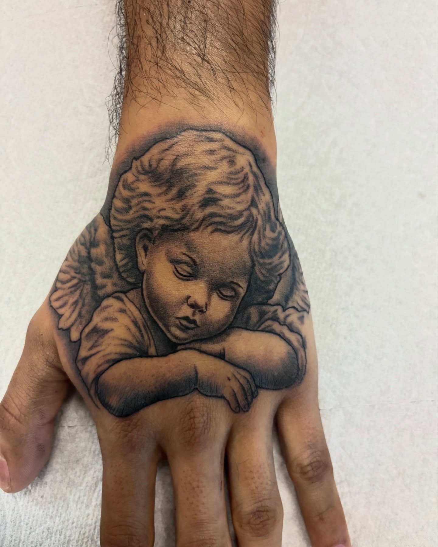 Angel black and grey tattoo on the hand by Cristiano Ochoa, Elk Grove, California