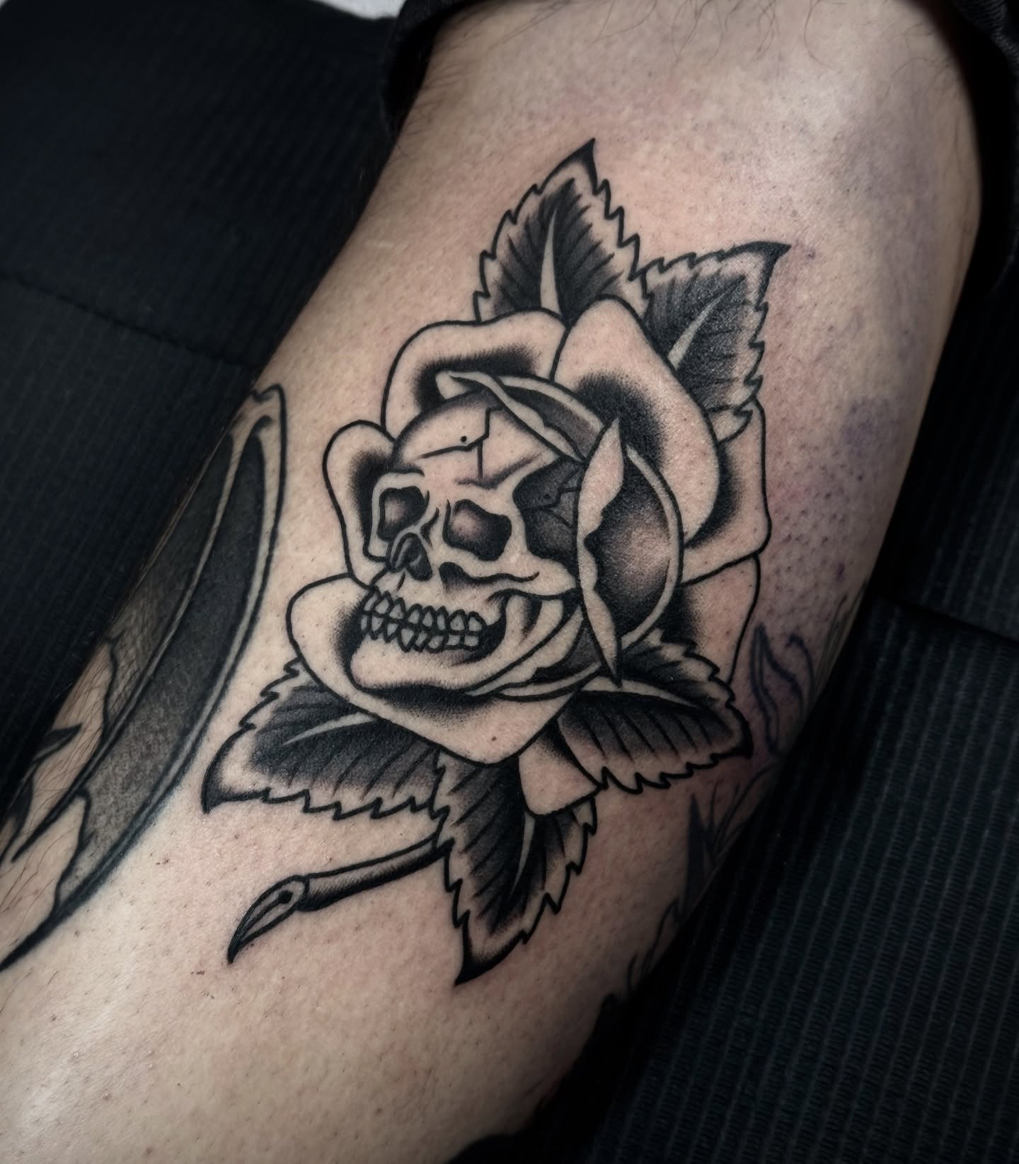Skull and rose black and grey tattoo on the thigh by Ally noel