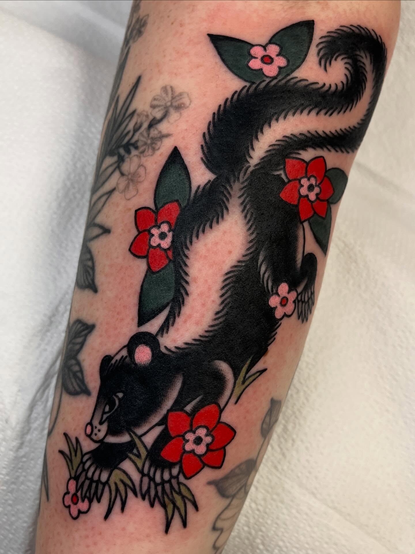 Skunk and flowers American traditional tattoo on the forearm by 🌞all Bodies Welcome🌞