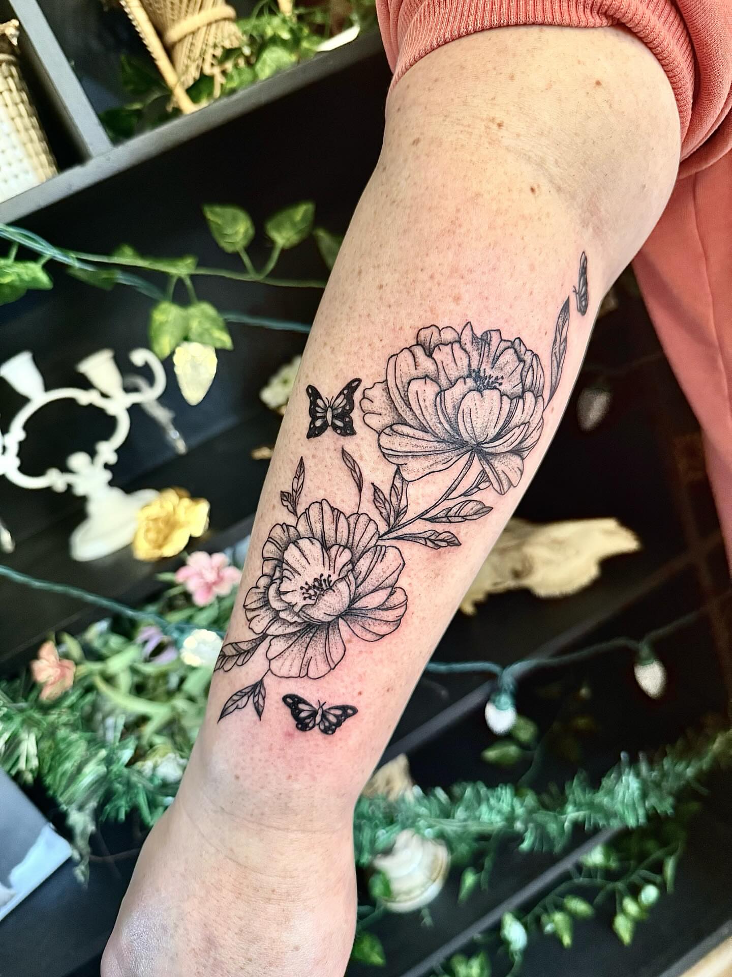 Flowers and butterflies black and grey tattoo on the forearm by Haley Bates