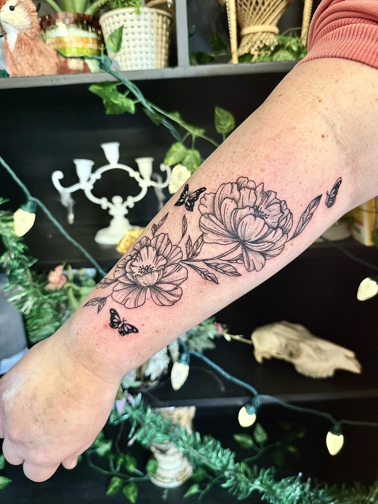 Flowers and butterflies black and grey tattoo on the forearm by Haley Bates